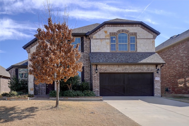 french provincial home featuring driveway, stone siding, a shingled roof, and brick siding