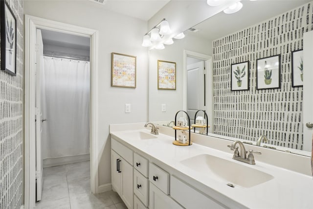 bathroom featuring double vanity, visible vents, a sink, and tile patterned floors