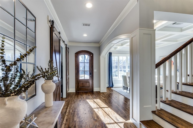 foyer entrance featuring dark wood-style floors, crown molding, visible vents, a barn door, and stairs