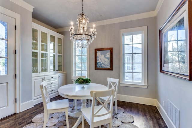 dining area with dark wood-style flooring, visible vents, and crown molding