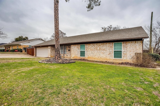 ranch-style house with a garage, a front yard, and brick siding