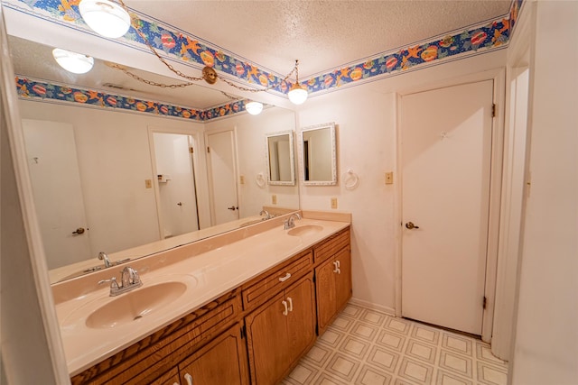 full bathroom with a sink, a textured ceiling, and double vanity