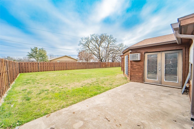 view of yard featuring a patio, french doors, a fenced backyard, and an AC wall unit