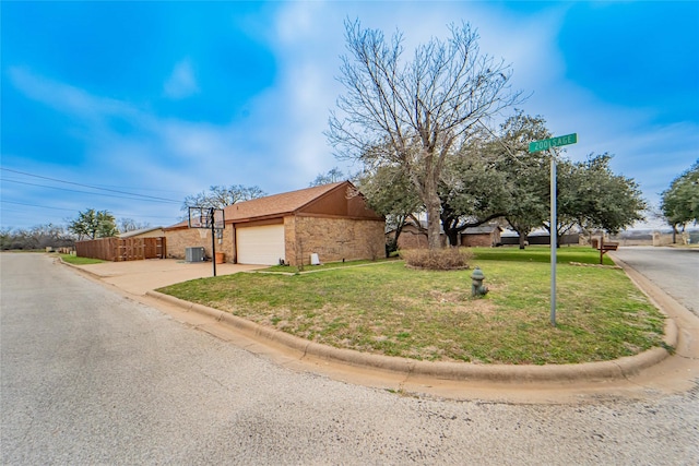 view of front of property with stone siding, a front lawn, concrete driveway, and cooling unit