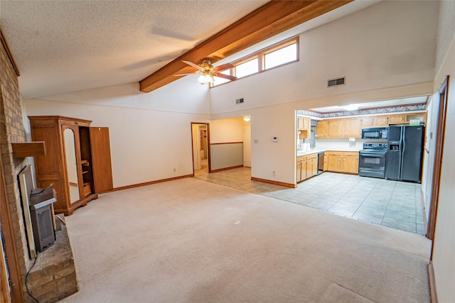 unfurnished living room featuring visible vents, a brick fireplace, light carpet, a textured ceiling, and beamed ceiling