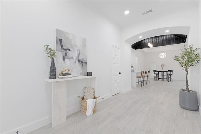 hallway with recessed lighting, baseboards, visible vents, and light wood finished floors