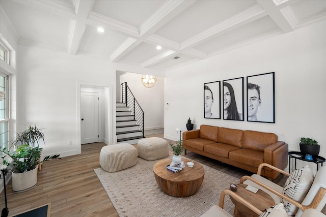 living area featuring beam ceiling, stairway, coffered ceiling, and wood finished floors