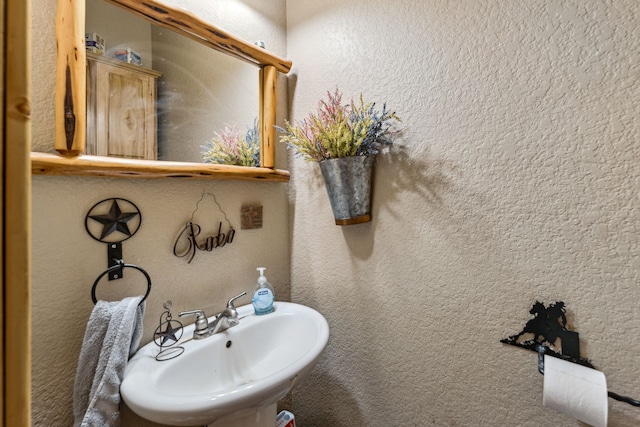 bathroom with a textured wall and a sink