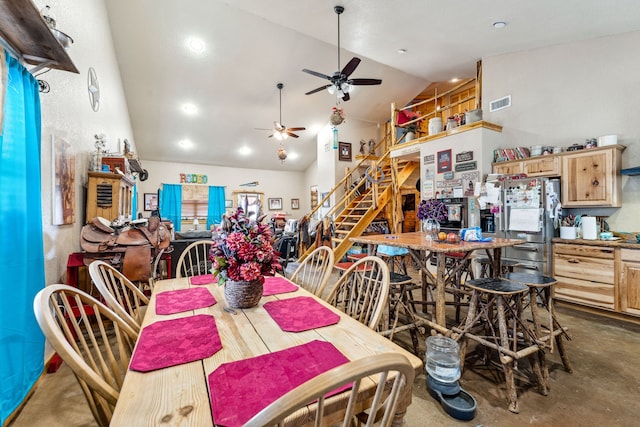 dining space with concrete flooring, high vaulted ceiling, visible vents, a ceiling fan, and stairs