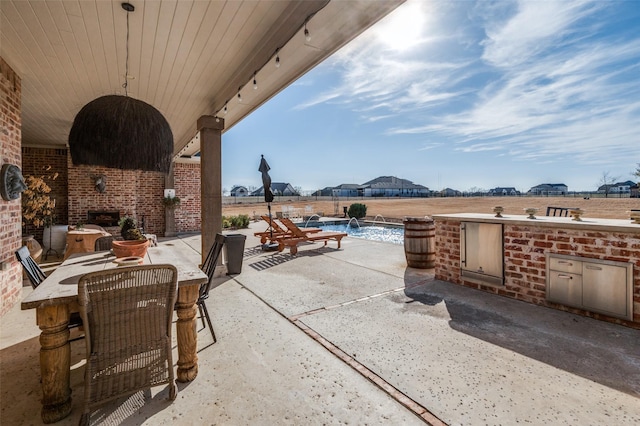 view of patio / terrace featuring a fenced in pool and an outdoor kitchen