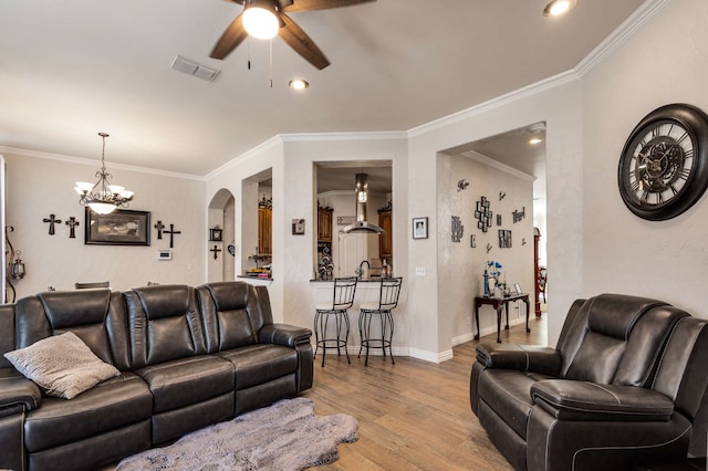 living area featuring arched walkways, wood finished floors, visible vents, and a ceiling fan