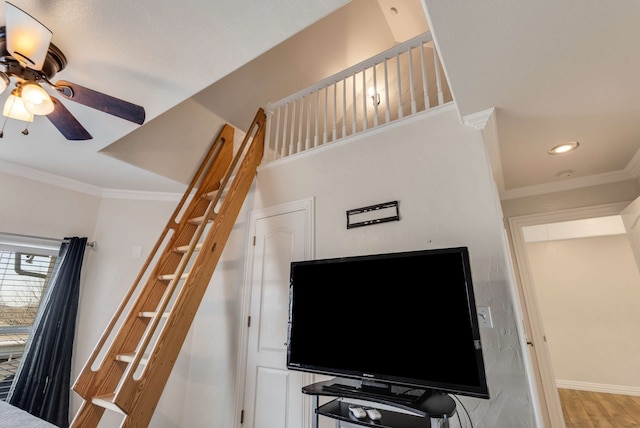 stairs featuring baseboards, ornamental molding, a ceiling fan, and wood finished floors