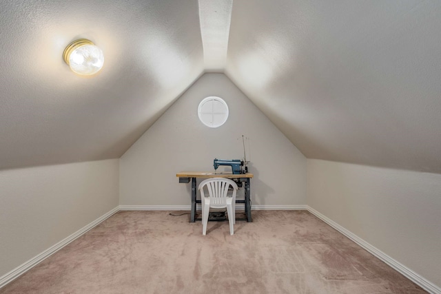 office featuring light carpet, vaulted ceiling, a textured ceiling, and baseboards