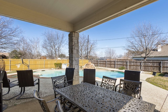 view of patio featuring outdoor dining space, a fenced backyard, and a fenced in pool