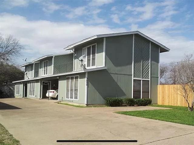 view of side of home featuring driveway and fence