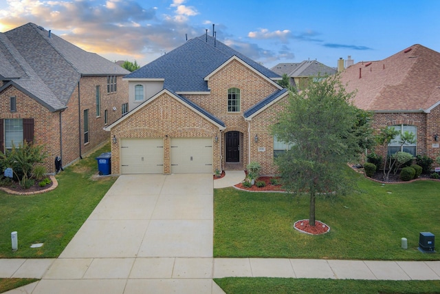 traditional-style home featuring a yard, brick siding, and an attached garage