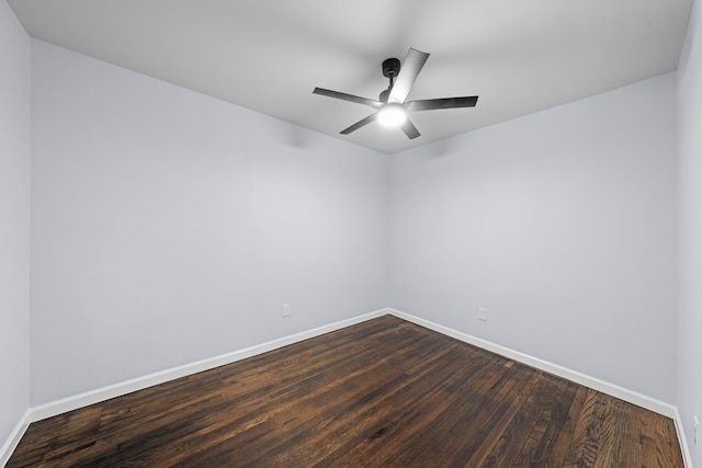 unfurnished room featuring dark wood finished floors, baseboards, and ceiling fan