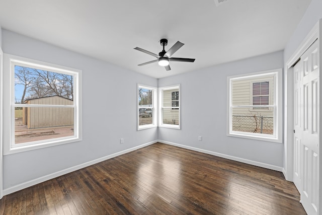 unfurnished bedroom with dark wood-style floors, ceiling fan, baseboards, and a closet