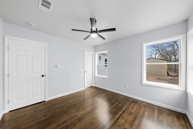 unfurnished room featuring a ceiling fan, baseboards, visible vents, and dark wood-type flooring