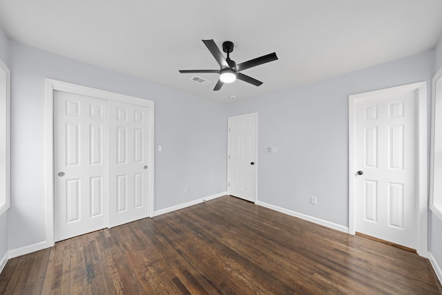 unfurnished bedroom featuring baseboards, visible vents, ceiling fan, dark wood-type flooring, and a closet