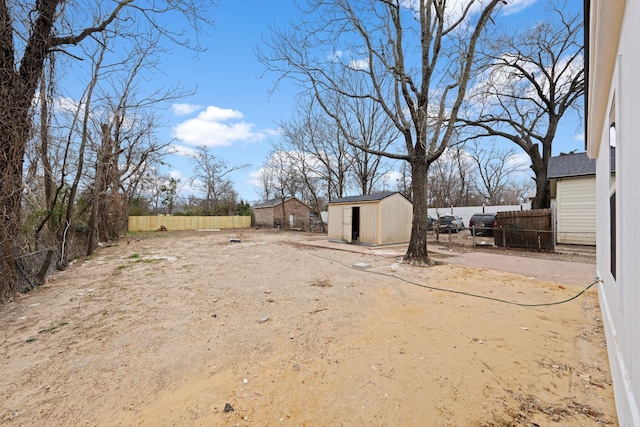 view of yard with an outbuilding, a fenced backyard, and a storage unit