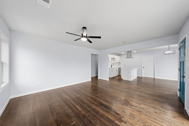 unfurnished living room with baseboards, visible vents, dark wood finished floors, and ceiling fan with notable chandelier