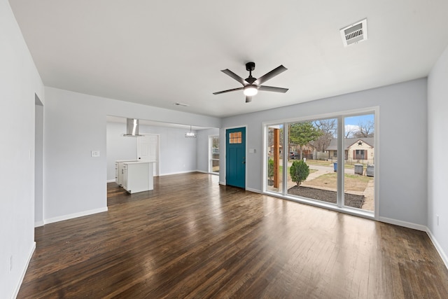 unfurnished living room with visible vents, dark wood finished floors, baseboards, and ceiling fan