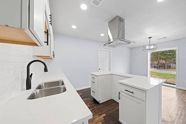 kitchen featuring island range hood, light countertops, and a sink