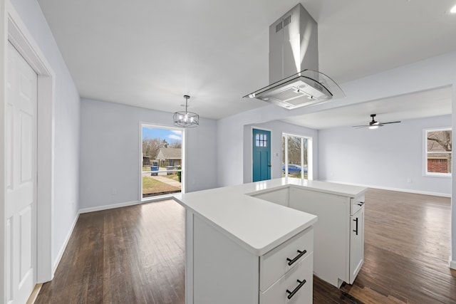 kitchen with white cabinets, open floor plan, a center island, island exhaust hood, and decorative light fixtures