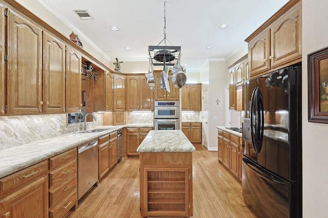 kitchen with visible vents, brown cabinetry, a kitchen island, a sink, and black appliances