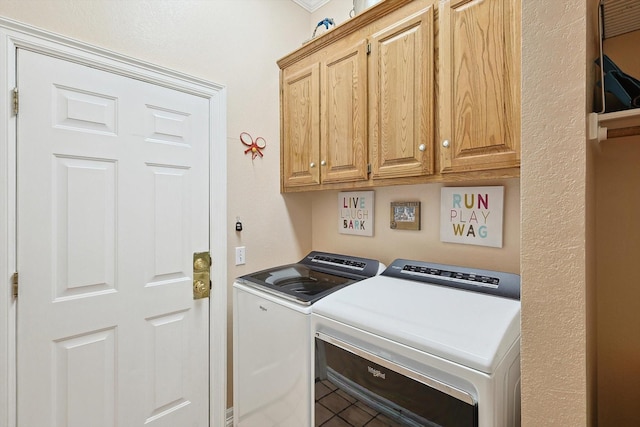 washroom featuring tile patterned flooring, cabinet space, and washer and dryer