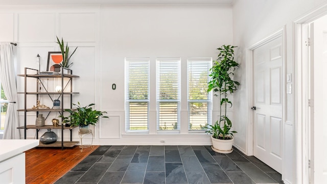 doorway to outside with plenty of natural light and a decorative wall