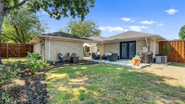 rear view of house featuring central AC unit, a fenced backyard, brick siding, a yard, and a patio area