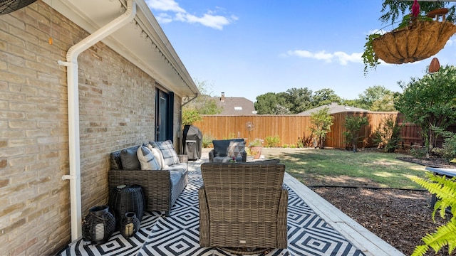 view of patio / terrace with a fenced backyard, an outdoor living space, and grilling area