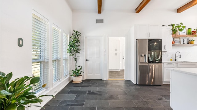 kitchen featuring visible vents, white cabinets, light countertops, stainless steel refrigerator with ice dispenser, and open shelves