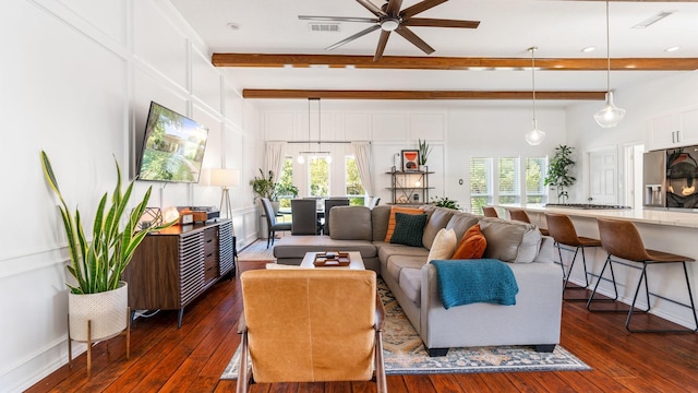 living area with beamed ceiling, plenty of natural light, and visible vents