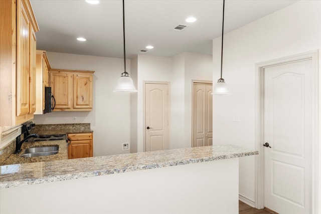 kitchen with visible vents, hanging light fixtures, stove, black microwave, and a peninsula