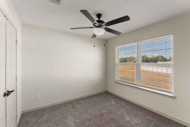 spare room featuring ceiling fan, baseboards, and carpet flooring