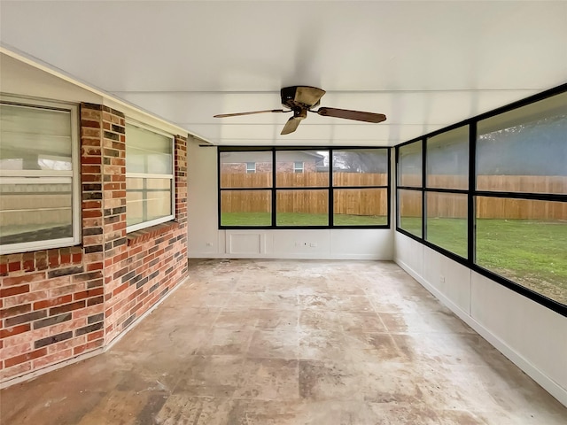 unfurnished sunroom with ceiling fan