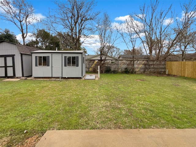 view of yard with a storage unit, an outdoor structure, and a fenced backyard