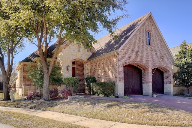 view of front of home featuring stone siding, fence, and brick siding