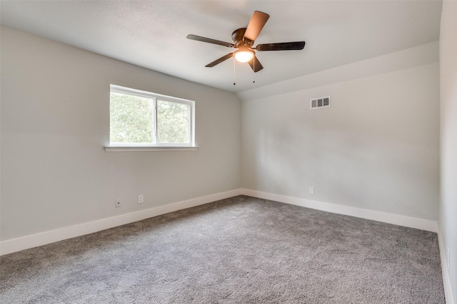 carpeted empty room featuring ceiling fan, visible vents, and baseboards