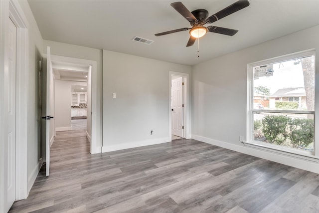 unfurnished bedroom with ceiling fan, light wood-type flooring, visible vents, and baseboards