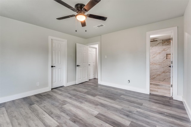 unfurnished bedroom featuring visible vents, a ceiling fan, connected bathroom, light wood-type flooring, and baseboards