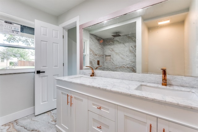 bathroom featuring double vanity, marble finish floor, a marble finish shower, and a sink