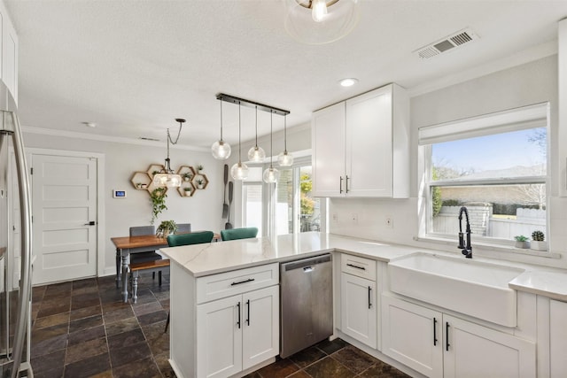 kitchen with visible vents, white cabinets, a peninsula, stainless steel appliances, and a sink