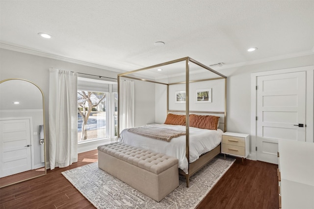 bedroom featuring a textured ceiling, dark wood-type flooring, visible vents, and crown molding