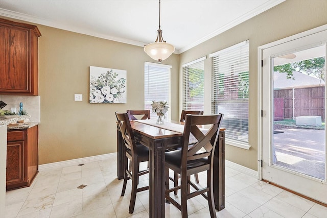 dining room with baseboards and crown molding