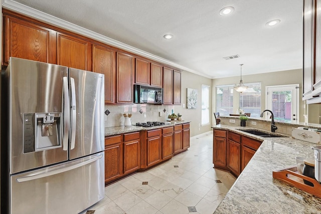 kitchen featuring light stone counters, pendant lighting, a sink, black microwave, and stainless steel fridge with ice dispenser