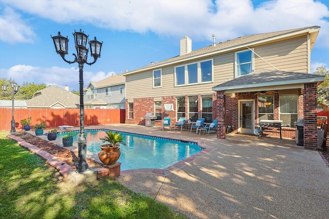 view of swimming pool with a fenced in pool, a patio, a grill, and fence